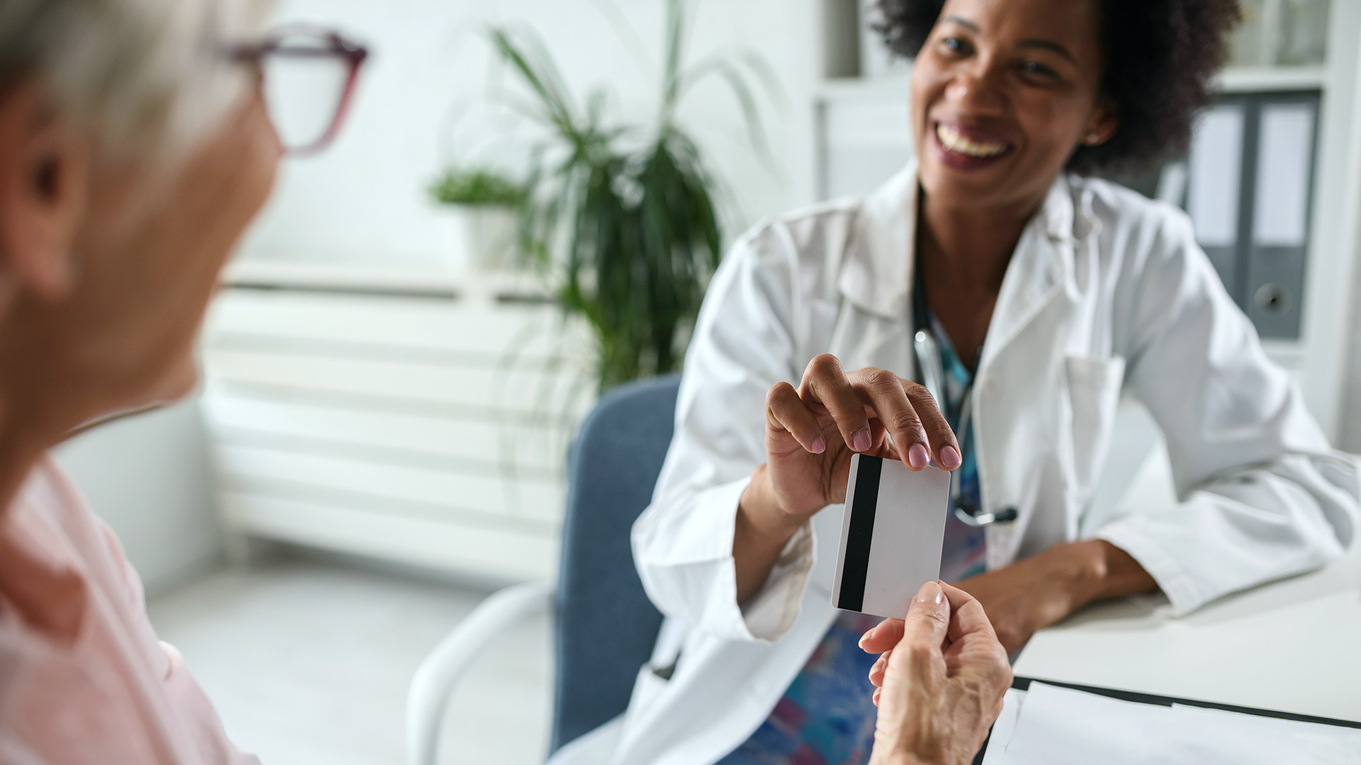 African Woman Doctor WIth Old Patient Credit Card Medical Billing Altron HealthTech